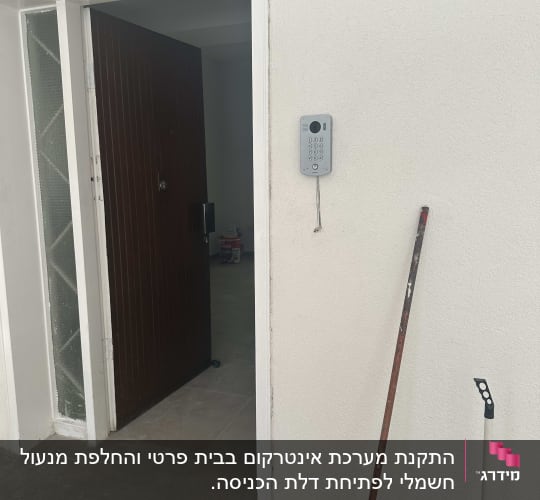 אינטרקום מותקן על קיר ליד דלת כניסה